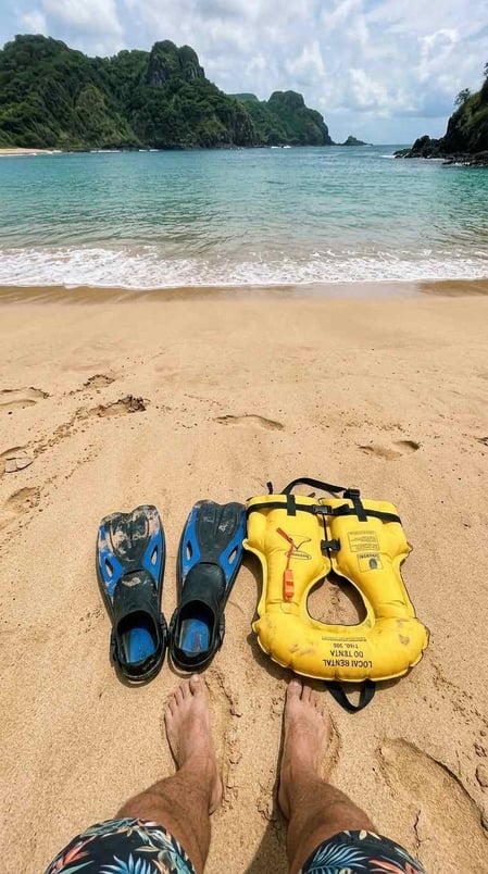 First person view of snorkeling fins and a life vest on the sand ready to visit Sueste Beach.