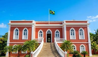 La facciata coloniale di un rosso brillante del Palazzo São Miguel a Fernando de Noronha, in Brasile, sotto un cielo azzurro e limpido con la bandiera brasiliana che sventola.