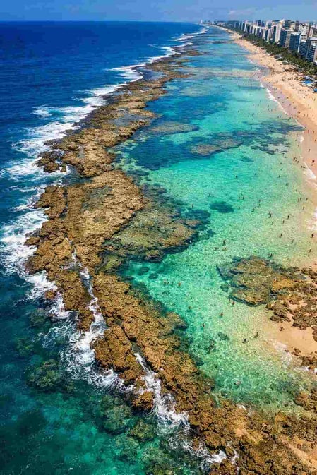 Vista aerea della barriera corallina della spiaggia di Boa Viagem a Recife, che forma piscine naturali sicure durante la bassa marea.