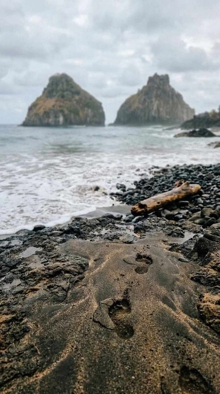 Uma visão autêntica das rochas vulcânicas e da areia dourada da Praia da Cacimba do Padre, em Fernando de Noronha, Brasil.